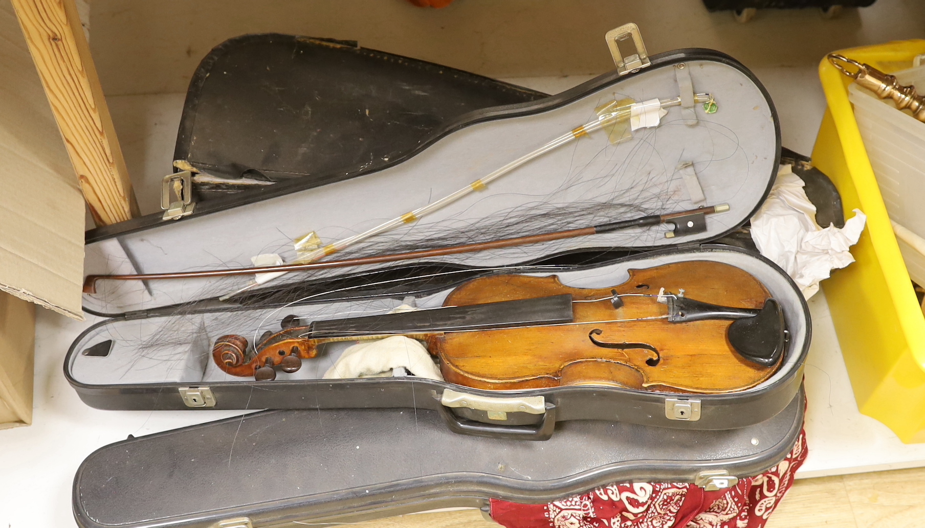 A violin, labelled Giovan Paulo Maggini, and three other violins, with bows in cases